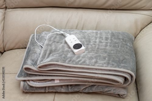 folded electric blanket with controller on a sofa
