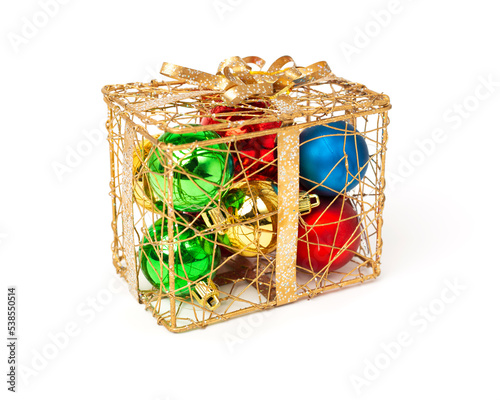 Bright colored balls in a golden cage. Christmas balls in a golden box. Christmas decoration on a white background.