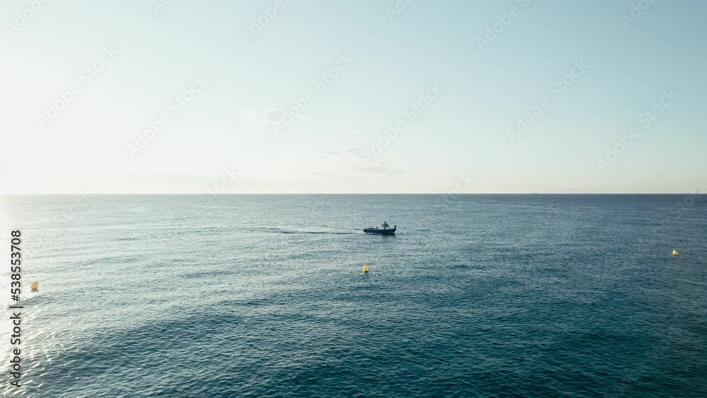 Dolly zoom on small lonely fish trawler passing in calm blue sea in the early morning, searching for rich fish spot. Dolly zoom on small lonely fish trawler passing in calm blue sea in the early morning, searching for rich fish spot.