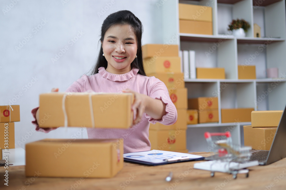 Startup SME small business entrepreneur of freelance Asian woman using laptop and box to receive and review orders online to prepare to pack sell to customers, online sme business ideas. Startup SME small business entrepreneur of freelance Asian woman using laptop and box to receive and review orders online to prepare to pack sell to customers, online sme business ideas.