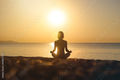Silhouette young woman practicing yoga on the beach at sunset, Karon Beach ,Phuket ,Thailand. For background and texture. High quality photo