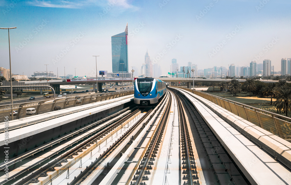 Dubai, UAE. Train, tube track with approaching train and  City view at the distance