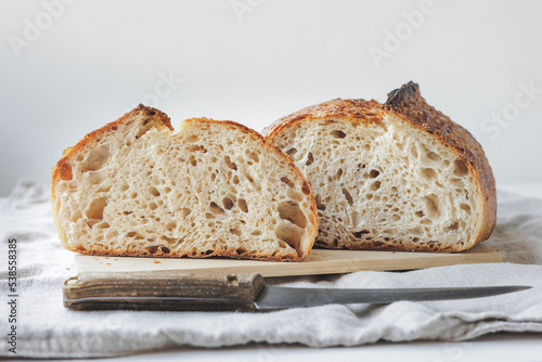 Round fresh bread lies on the cutting board. Baking and confectionery in a bakery or restaurant. homemade yeast-free sourdough bread. Healthy food