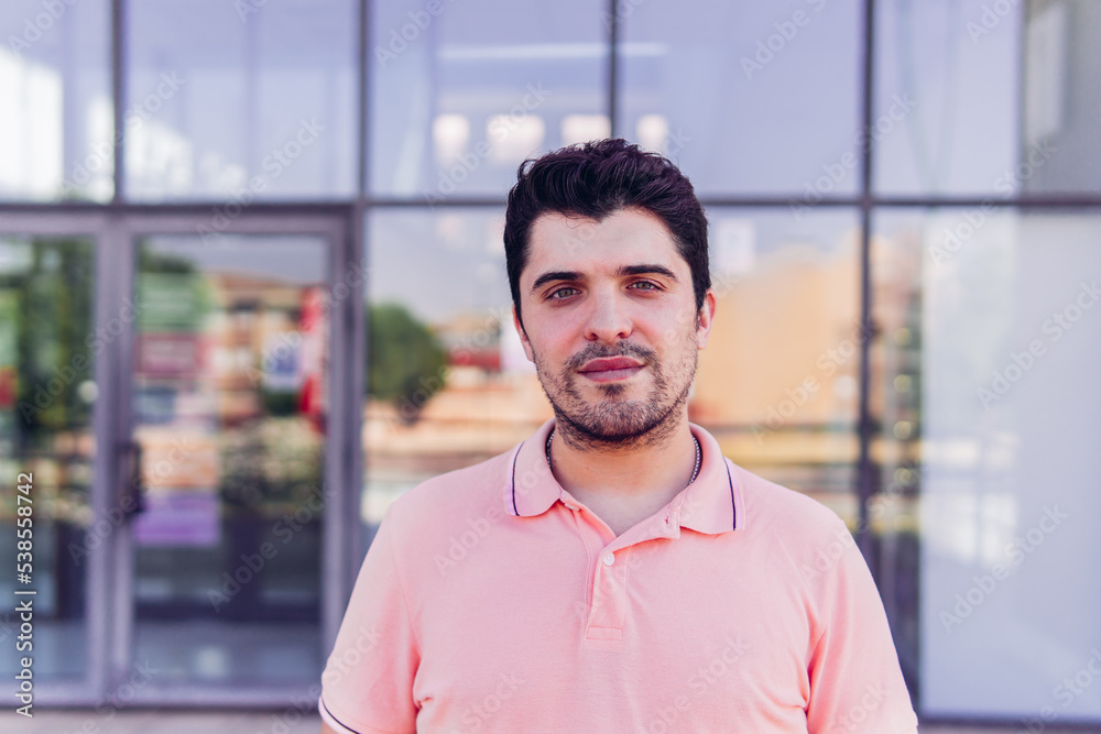 Portrait of a young adult man near the window looking at the camera. Portrait of a young adult man near the window looking at the camera.