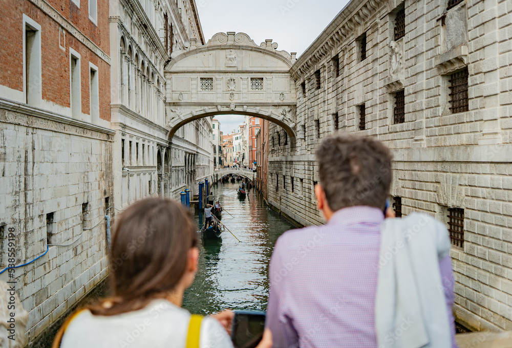 Tourists  tanding on Ponte della Paglia, watching gondolas 