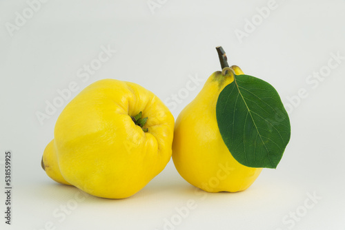 Owoce pigwy z zielonym liściem na białym tle © photogam
