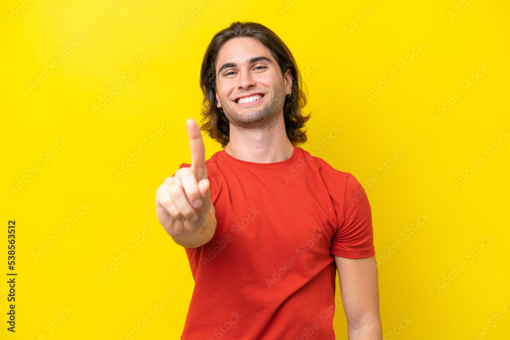 Caucasian handsome man isolated on yellow background showing and lifting a finger Caucasian handsome man isolated on yellow background showing and lifting a finger