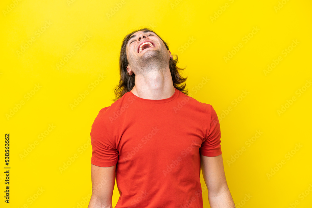Caucasian handsome man isolated on yellow background laughing Caucasian handsome man isolated on yellow background laughing