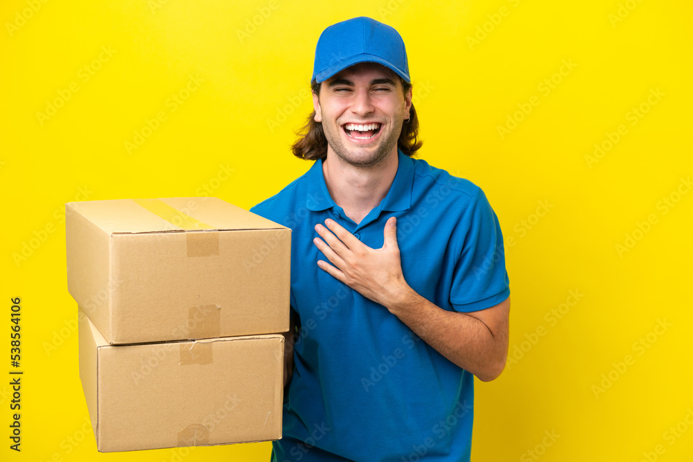 Delivery handsome man isolated on yellow background smiling a lot Delivery handsome man isolated on yellow background smiling a lot