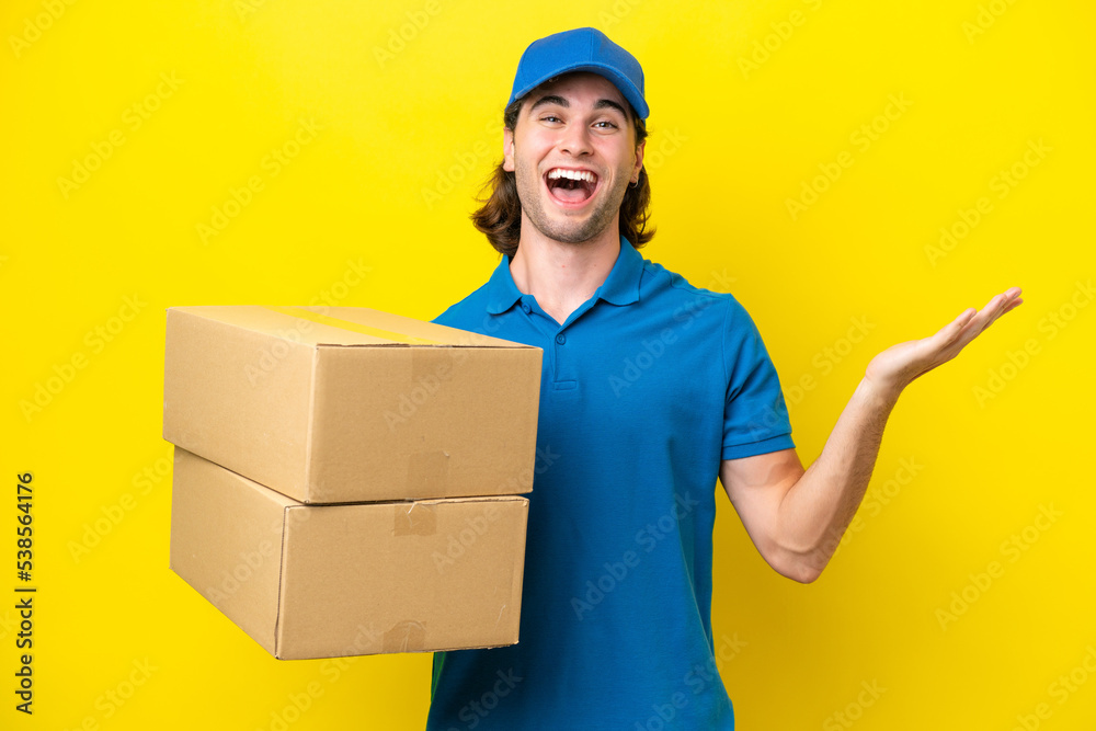 Delivery handsome man isolated on yellow background with shocked facial expression Delivery handsome man isolated on yellow background with shocked facial expression