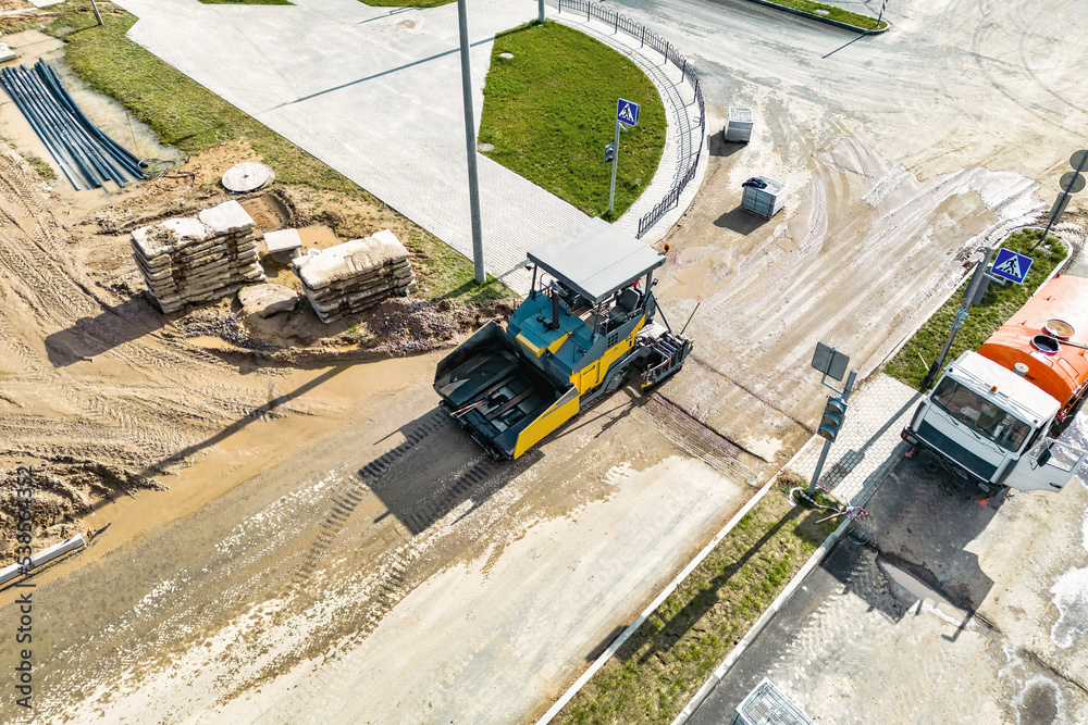 Asphalt laying equipment. Asphalt paver machine on the road repair site. Road renewal process, construction work. View from above. Drone photography. Asphalt laying equipment. Asphalt paver machine on the road repair site. Road renewal process, construction work. View from above. Drone photography.