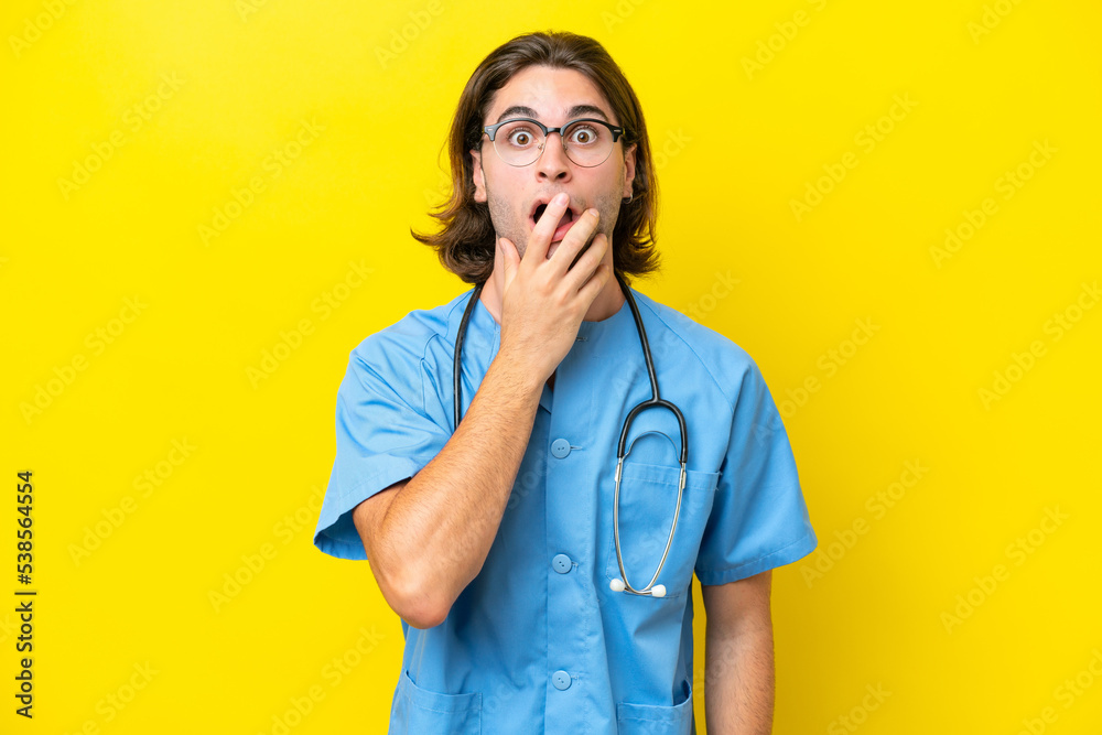 Young surgeon caucasian man isolated on yellow background surprised and shocked while looking right Young surgeon caucasian man isolated on yellow background surprised and shocked while looking right