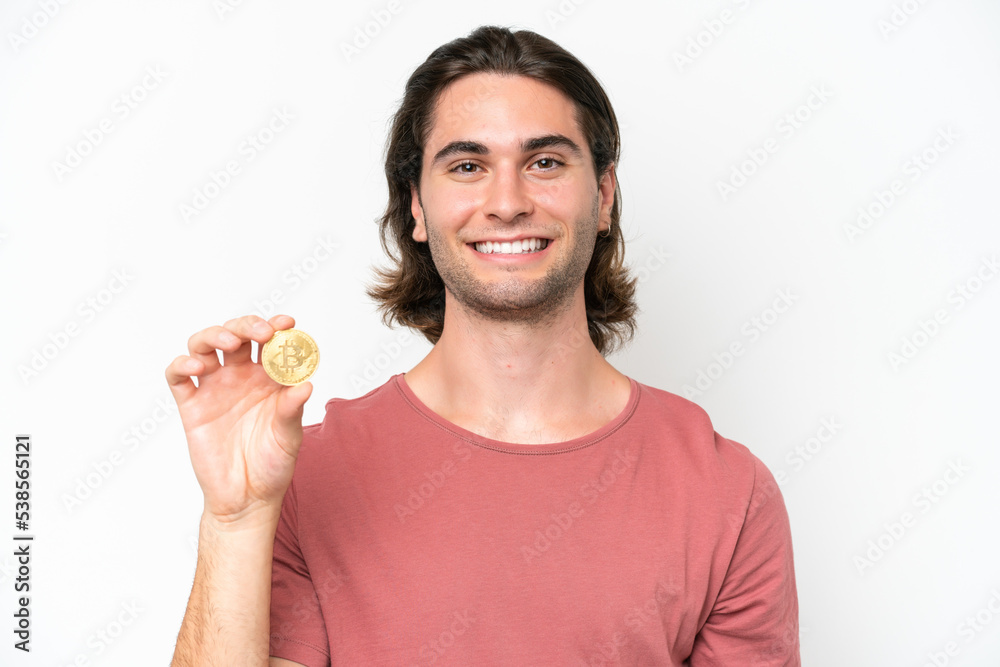 Young handsome man holding a Bitcoin isolated on white background smiling a lot Young handsome man holding a Bitcoin isolated on white background smiling a lot