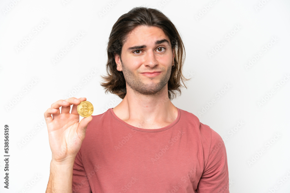 Young handsome man holding a Bitcoin isolated on white background with sad expression Young handsome man holding a Bitcoin isolated on white background with sad expression