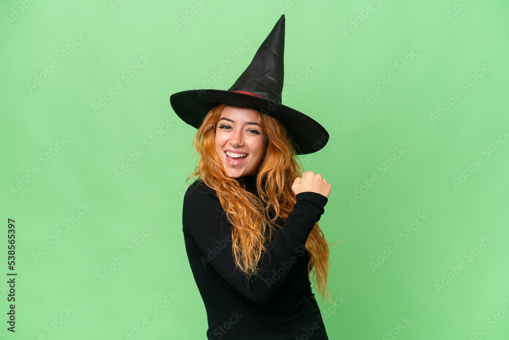 Young caucasian woman costume as witch isolated on green screen chroma key background celebrating a victory Young caucasian woman costume as witch isolated on green screen chroma key background celebrating a victory