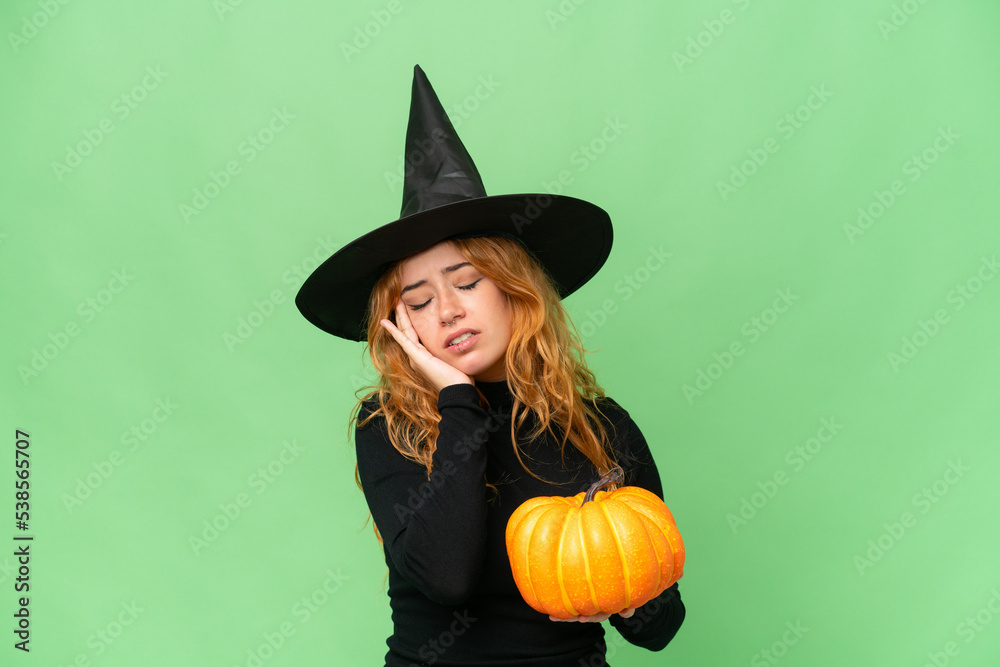 Young caucasian woman costume as witch holding a pumpkin isolated on green screen chroma key background with headache Young caucasian woman costume as witch holding a pumpkin isolated on green screen chroma key background with headache
