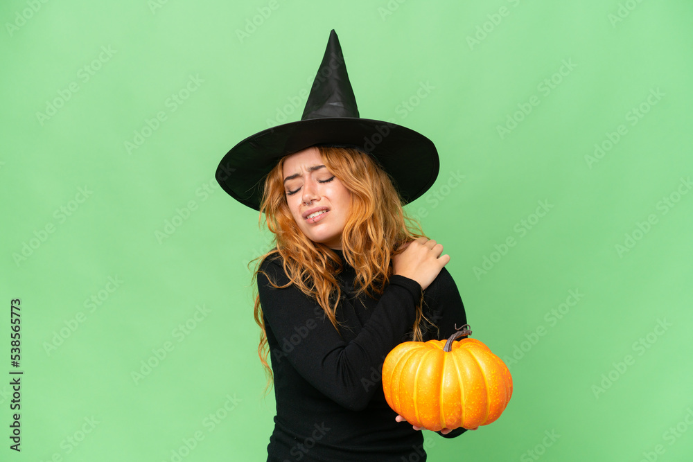 Young caucasian woman costume as witch holding a pumpkin isolated on green screen chroma key background suffering from pain in shoulder for having made an effort Young caucasian woman costume as witch holding a pumpkin isolated on green screen chroma key background suffering from pain in shoulder for having made an effort