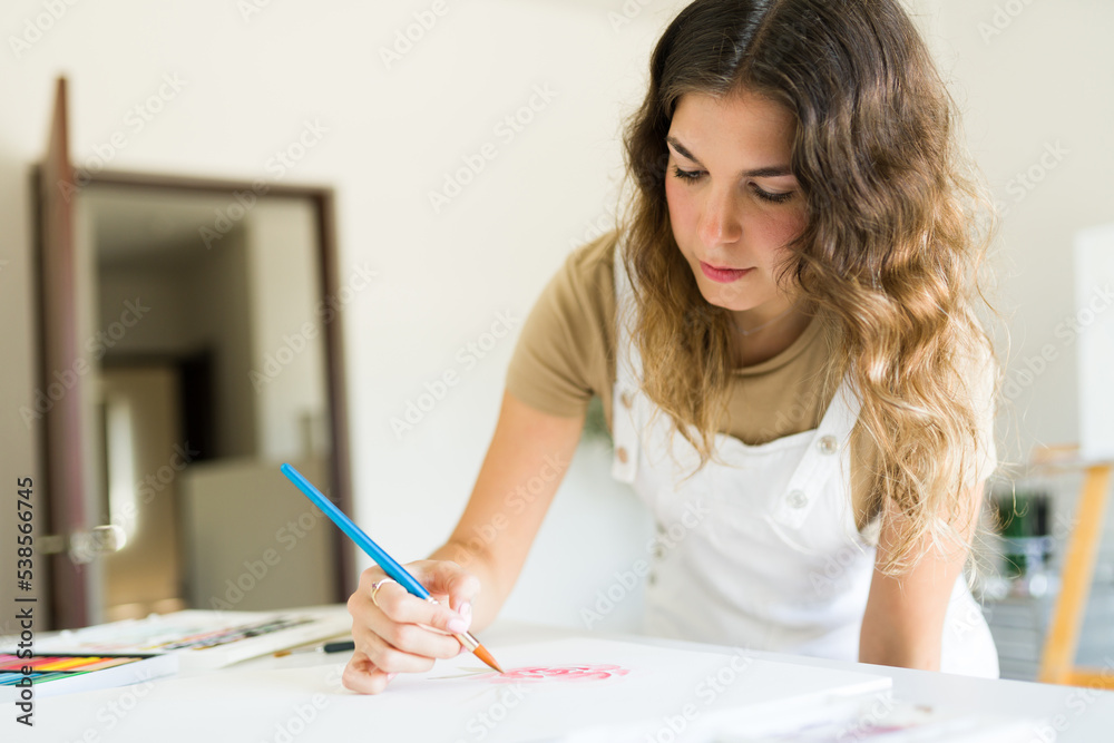 Focused caucasian woman doing a painting