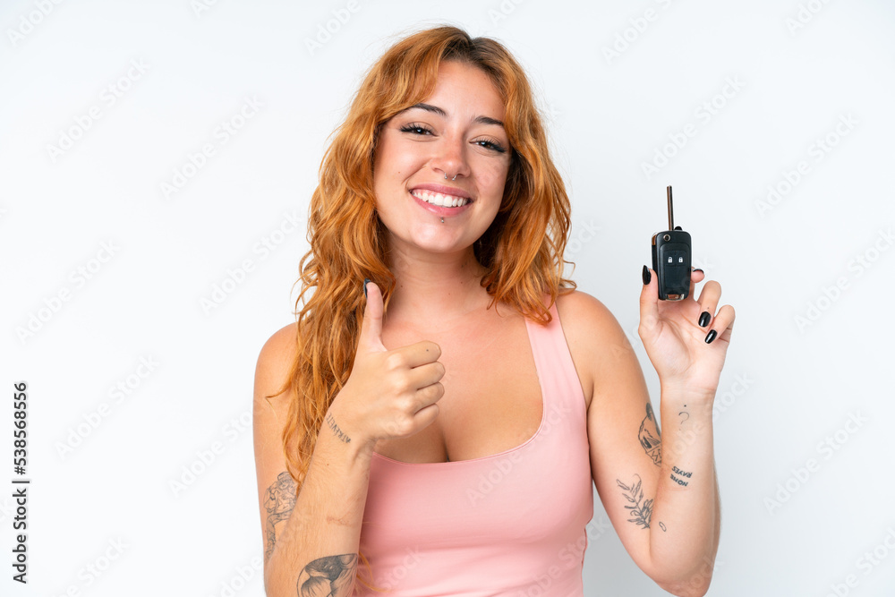 Young caucasian woman holding car keys isolated on white background with thumbs up because something good has happened Young caucasian woman holding car keys isolated on white background with thumbs up because something good has happened