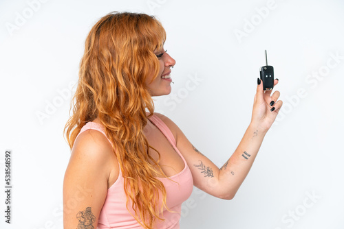 Young caucasian woman holding car keys isolated on white background with happy expression