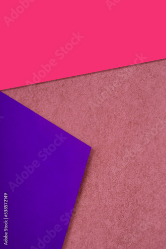 Plain and Textured neon blue pink purple papers randomly laying to form M like pattern and triangle for creative cover design idea