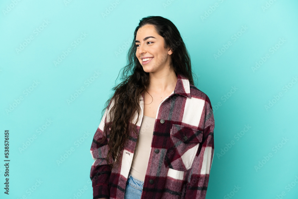 Young caucasian woman isolated on blue background looking side Young caucasian woman isolated on blue background looking side