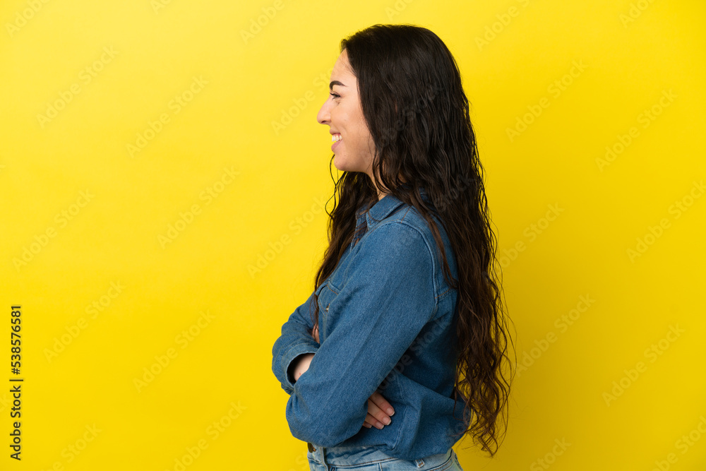 Young caucasian woman isolated on yellow background in lateral position Young caucasian woman isolated on yellow background in lateral position