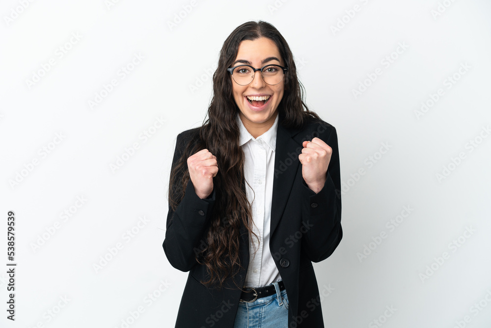 Young business woman isolated on white background celebrating a victory in winner position