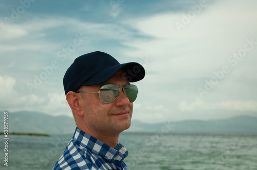 Man in sunglasses on the beach. Beautiful mountain lake. © Катерина Воробьева