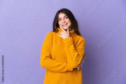 Young caucasian woman isolated on purple background happy and smiling © luismolinero