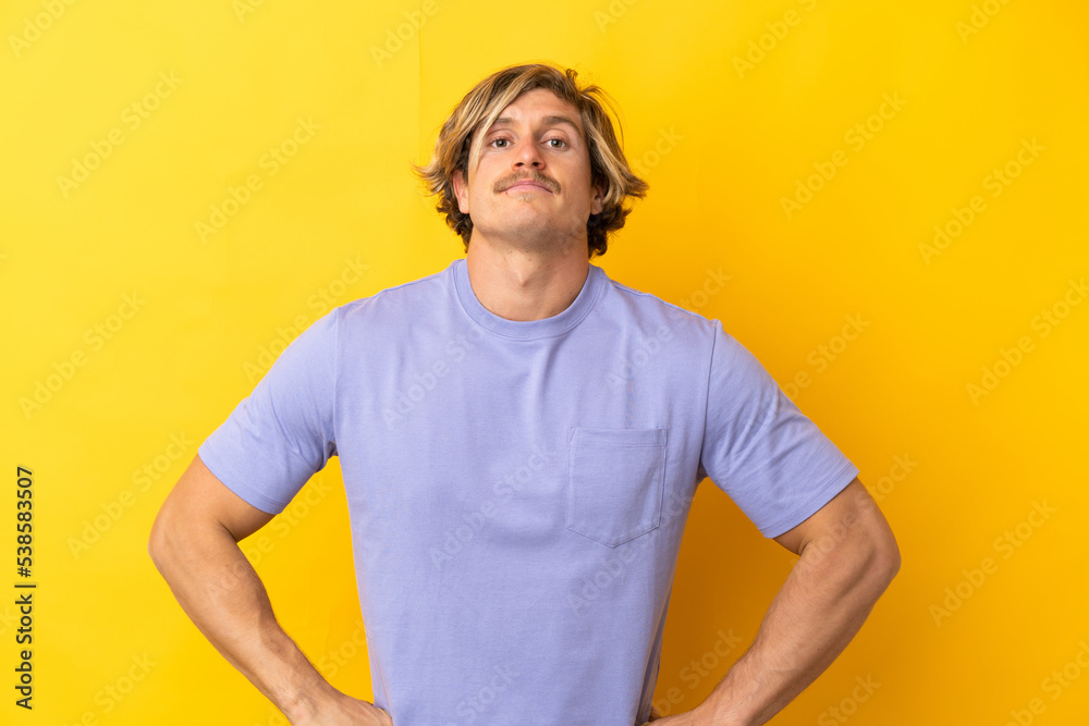 Handsome blonde man isolated on yellow background angry Handsome blonde man isolated on yellow background angry