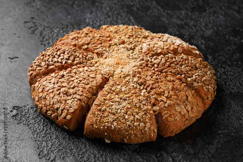 Fresh Homemade seeded share bread on rustic dark background