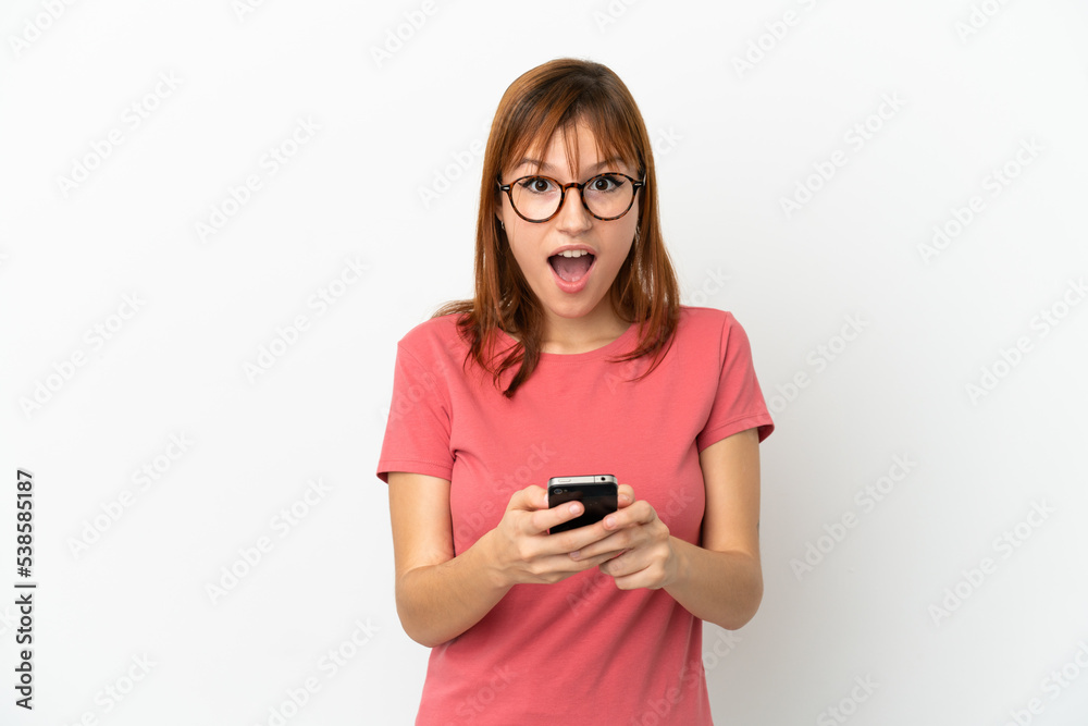 Redhead girl isolated on white background surprised and sending a message Redhead girl isolated on white background surprised and sending a message