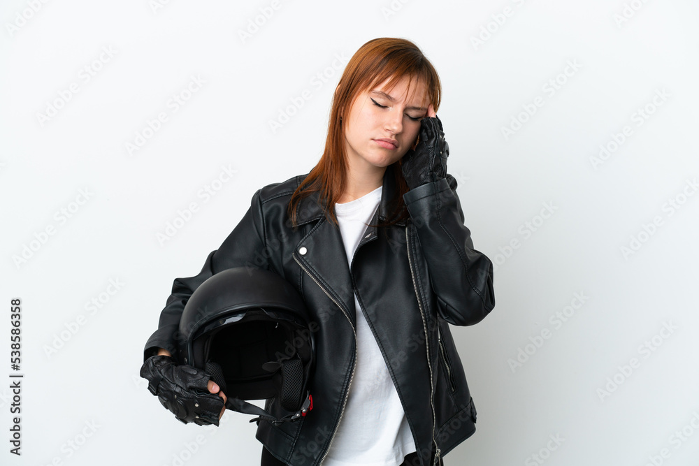 Redhead girl with a motorcycle helmet isolated on white background with headache Redhead girl with a motorcycle helmet isolated on white background with headache