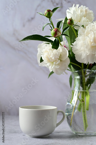 Peonies in a vase. Stylish white peonies in the hands of a florist. The florist girl collected a bouquet. Pruning spring white flowers. A gift for the holiday. Fresh floral