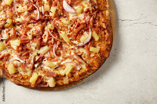 Gourmet wood fired ham and pineapple pizza on table photo