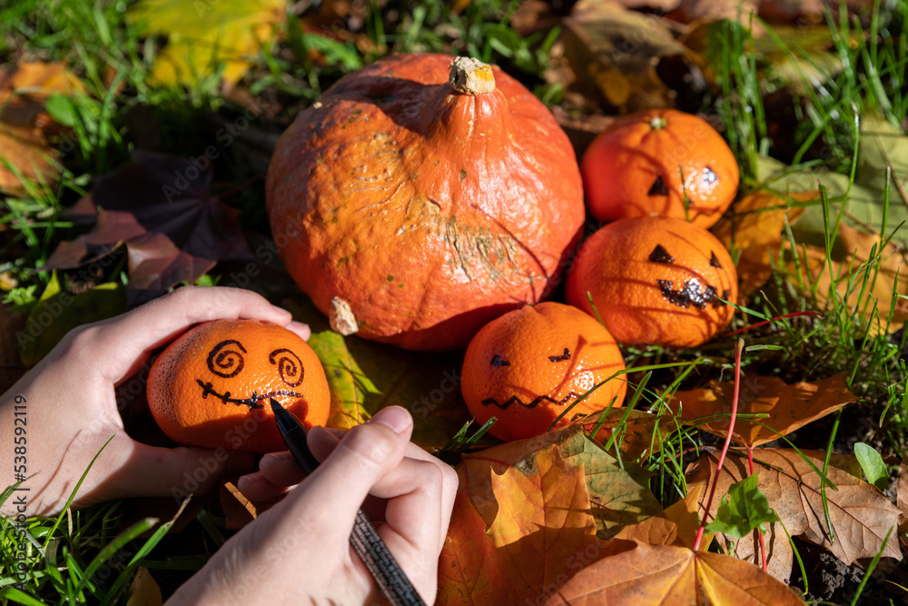 Kindliche Hände basteln Halloween Deko im herbstlichen Garten mit