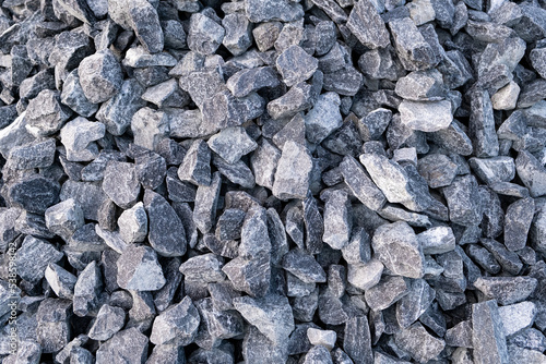 Heap of Gray crushed stones cobblestones on street road construction site. Full frame textured background.