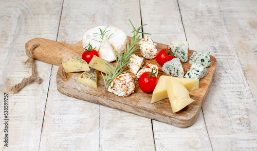 Assortment of different cheese types on wooden board. Different types of delicious cheese, closeup. Copy space. Cheese Collection. photo