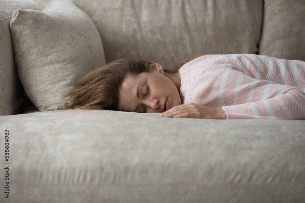 Close up tired woman has nap lying on sofa looks drained without energy, deprived of strength or vitality after hard workday. Unmotivated female feels mental physical exhaustion after sleepless night Close up tired woman has nap lying on sofa looks drained without energy, deprived of strength or vitality after hard workday. Unmotivated female feels mental physical exhaustion after sleepless night