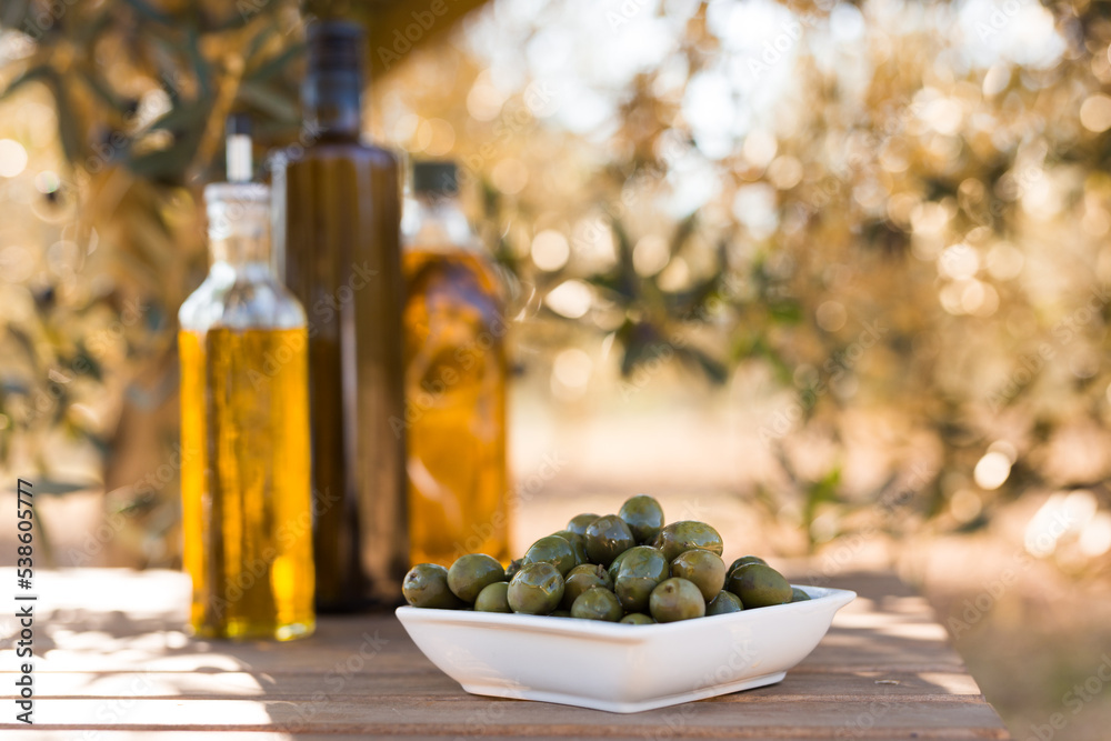 green olives and oil on table in olive grove green olives and oil on table in olive grove