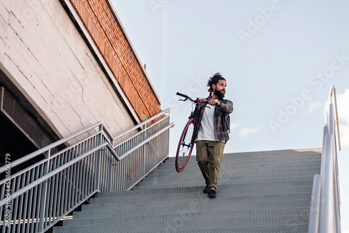 Bearded Man Carrying his Bike © santypan