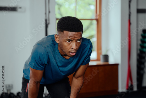 Focused young black man in sportswear taking a break at the gym