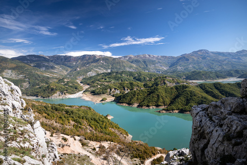 The water reservoir Lake Bovilla surrounded by mountains, blue sky, in Albania