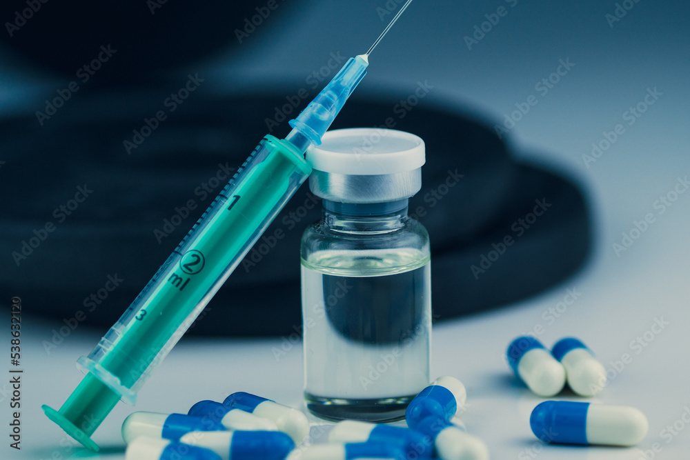 dumbbells, syringe with needle, pills and vial with steroids. illegal doping in sport concept dumbbells, syringe with needle, pills and vial with steroids. illegal doping in sport concept
