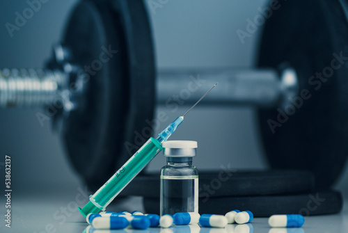 dumbbells, syringe with needle, pills and vial with steroids. illegal doping in sport concept. new years resolutions photo