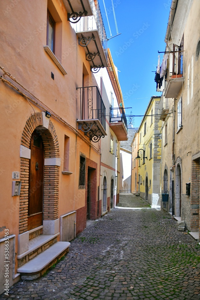 Fototapeta premium A narrow street between the old stone houses of Frosolone, a medieval village in the Molise region of Italy.