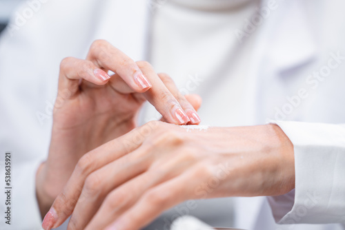 Beauty eco cosmetic research and development concept  Scientist or Pharmacist applying moisturizer lotion on her hand for efficacy testing of natural organic skincare products in laboratory