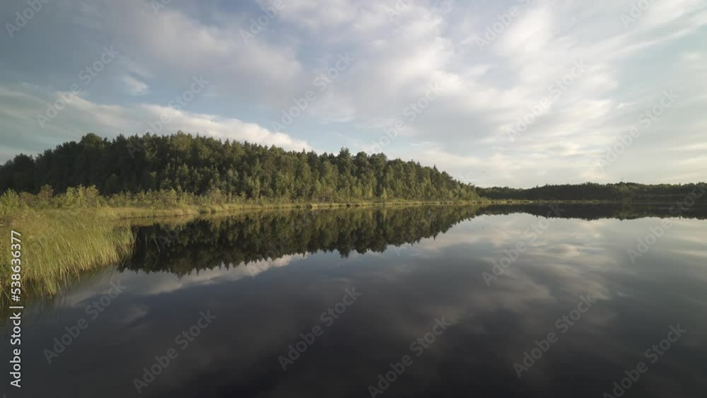 Time-lapse clouds are moving fast, a glacial lake, a forest reflection Time-lapse clouds are moving fast, a glacial lake, a forest reflection