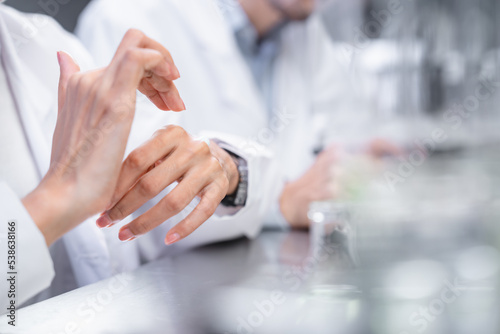 Beauty eco cosmetic research and development concept, Scientist or Pharmacist applying moisturizer lotion on her hand for efficacy testing of natural organic skincare products in laboratory